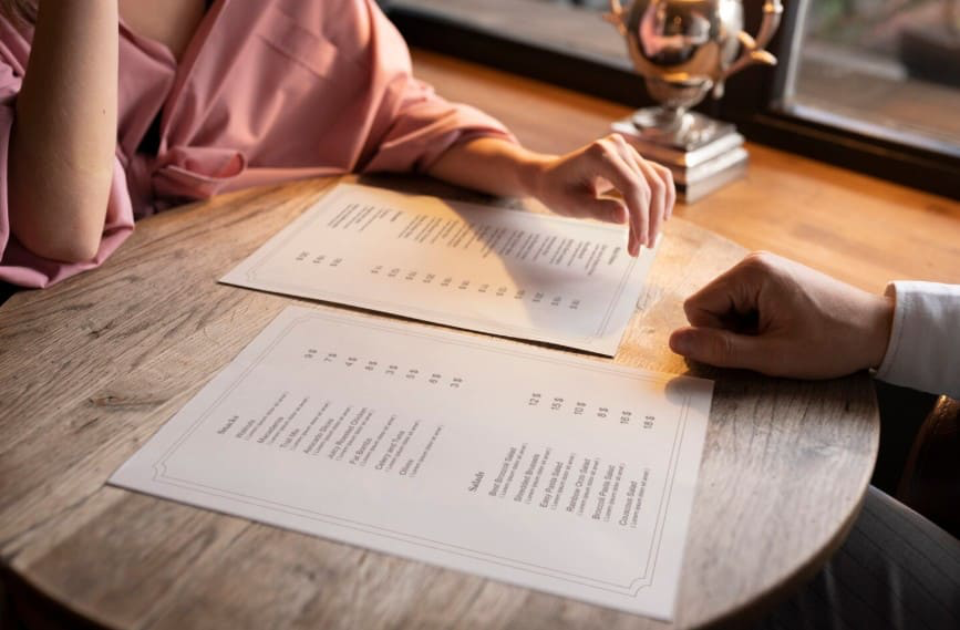 Cliente revisando una carta de precios transparente en un bar
