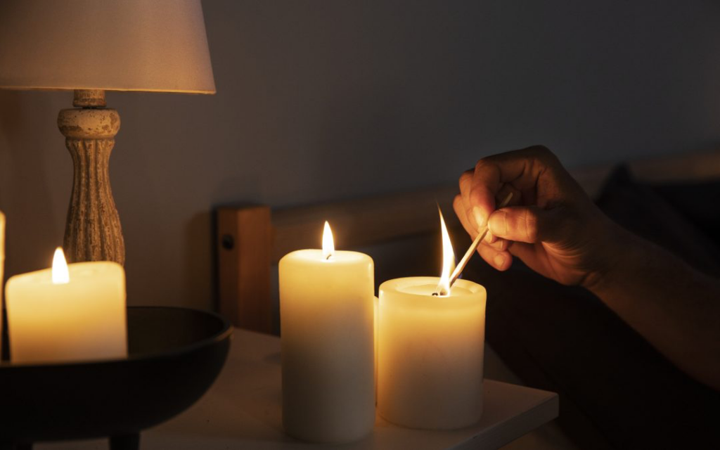 Interior de una vivienda a oscuras con una vela debido a cortes de suministro