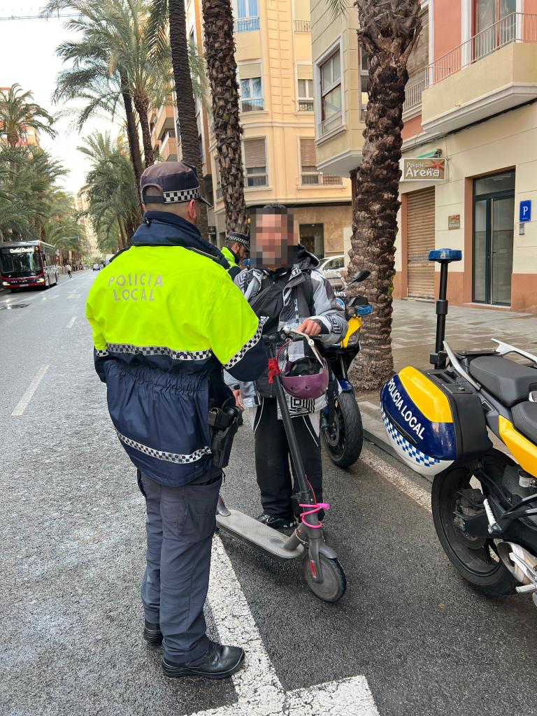 Agente de policía municipal comprobando la placa de homologación de un patinete eléctrico